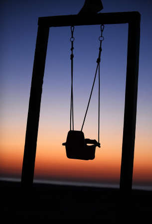Baby swing on the beach in the dawnの写真素材