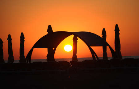 Closed parasols on the beach in the dawnの写真素材