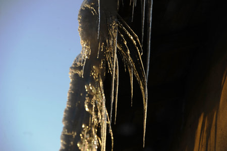 Icicles from the roof of a house in the sunlight
