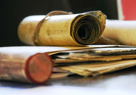 Various old scrolled documents on a shiny tableの写真素材