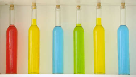 Colored bottles arranged nicely on the shelfの写真素材