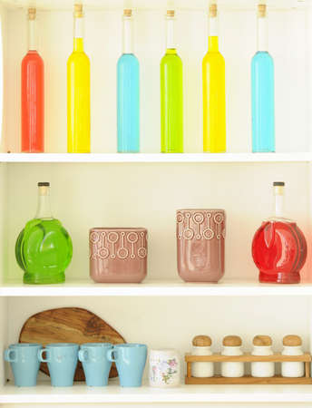 Colored bottles arranged nicely on the shelfの写真素材
