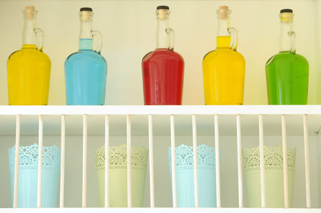 Colored bottles arranged nicely on the shelfの写真素材