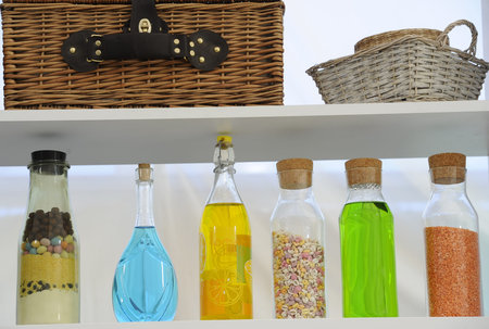 Colored bottles arranged nicely on the shelfの写真素材