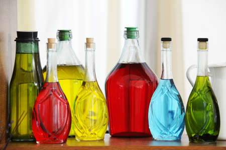 Colored bottles arranged nicely on the shelfの写真素材