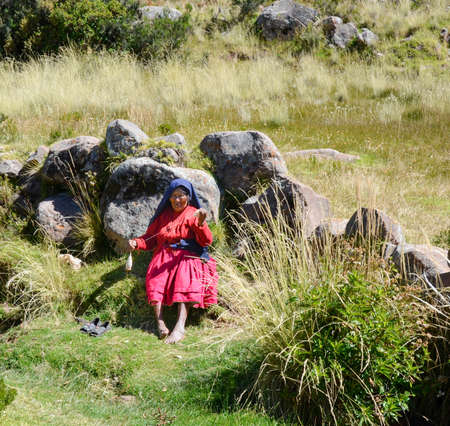 TAQUILE ISLAND, PUNO, PERU. MAY 31, 2013: People from Aymara community, in their colourful costumes, are famous for their fine decorative weavingのeditorial素材