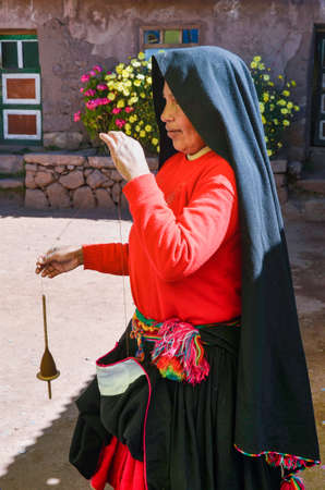 TAQUILE ISLAND, PUNO, PERU. MAY 31, 2013: People from Aymara community, in their colourful costumes, are famous for their fine decorative weavingのeditorial素材