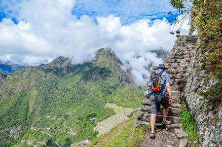 MACHU PICCHU, CUSCO REGION, PERU- JUNE 4, 2013: Tourist climbing Huayna Picchu mountain for one of the best panoramic views of Machu Picchuのeditorial素材