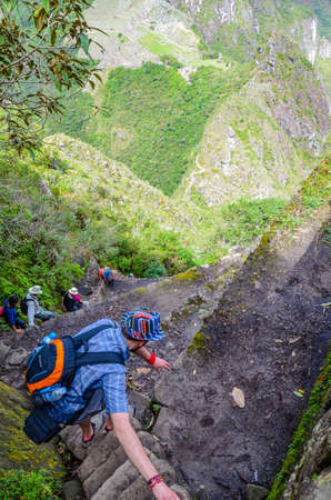 MACHU PICCHU, CUSCO REGION, PERU- JUNE 4, 2013: Tourist climbing Huayna Picchu mountain for one of the best panoramic views of Machu Picchuのeditorial素材