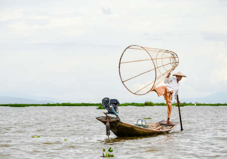 INLE, SHAN STATE, MYANMAR- SEPTEMBER 20, 2016: Traditional Burmese fisherman with fishing net in Inle Lakeのeditorial素材