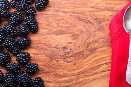 Blackberry on wood with lots copyspace and metal vintage spoon on a sideの写真素材