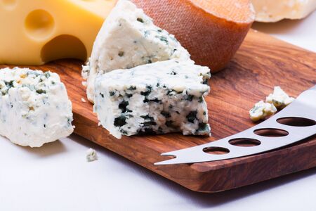 Cheeses on chopping board on white backgroundの写真素材