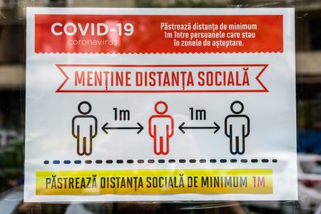 Bucharest, Romania - June 6, 2020: Poster indicating 1 meter social distancing request behind a...