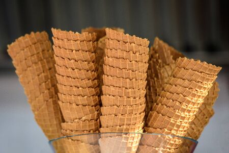 Many tasty ice cream cones ready to be used, displayed at a store window at a street food marketの写真素材