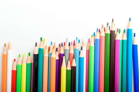 Group of many mixed colourful pencils isolated isolated on a white paper, children school or office suppliers photographed with soft focus from side view, with space for textの写真素材