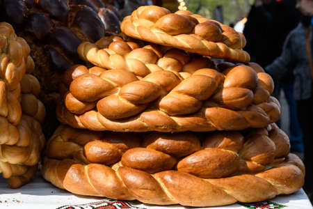 Stack of traditional colaci or baked buns, home made specialty of bread displayed for sale at a street food market in Bucharest, Romaniaの写真素材