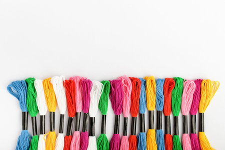 Line with many mixed vivid colored sewing threads for embroidery isolated on a white table, top view...