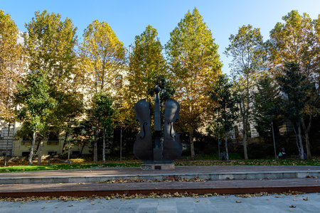 Landscape with statue and vivid green and yellow plants, green lime trees and grass in a sunny autumn day in Coltea Park in Bucharest, Romaniaの写真素材