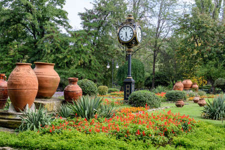 Landscape with the main entrance with vivid flowers and green plants, green lime trees and grass in a sunny summer day in Cismigiu Garden in Bucharest, Romaniaの写真素材