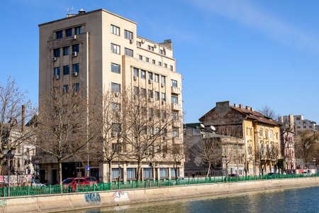 Bucharest, Romania, 13 February 2021 - Landscape with large old trees and old buildings near Dambovita river and clear blue sky in the center of Bucharest, Romania, in a sunny winter dayのeditorial素材