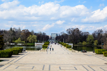 Bucharest, Romania, 20 March 2021:Landscape with the main alley and many large green trees near the lake in Carol Park in Bucharest, Romania, in a sunny spring dayのeditorial素材