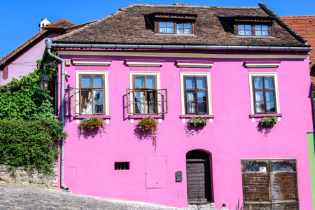 Old colorful painted house in the historical center of the Sighisoara citadel, in Transylvania (Transilvania) region of Romania, in a sunny summer dayの写真素材