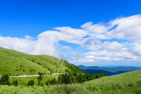 Scenic view over Bucegi Mountains (Muntii Bucegi) in Romania in a sunny summer day with clear blue sky and white cloudsの写真素材