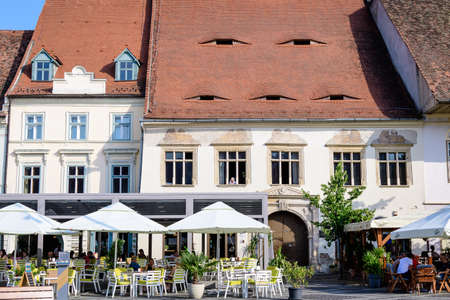 Sibiu, Romania - 15 July 2021: Renovated old historical buildings in the Large Square (Piata Mare) in Transylvania (Transilvania) region, in a sunny summer dayのeditorial素材