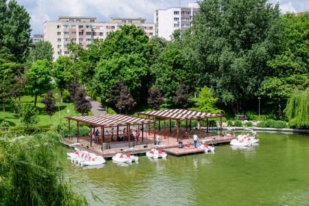 Bucharest, Romania - 29 May 2021: Landscape with lake and vivid green trees in Drumul Taberei Park (Parcul Drumul Taberei) also known as Moghioros Park, in Bucharest, Romania, in a cloudy summer dayのeditorial素材