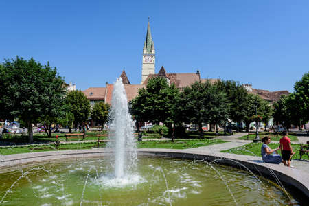 Medias, Romania, 14 July 2021: City landscape with Ferdinand I King Square (Piata Regele Ferdinand I) and green park in the old city center, in Transylvania (Transilvania) region, Romania, in a sunny summer dayのeditorial素材