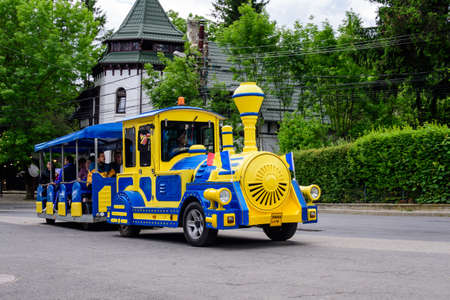 Sinaia, Romania - 3 July 2021: Colorful train for children in a street in the center of the city  close to Bucegi Mountains (Muntii Bucegi) in Prahova Valley (Valea Prahovei) in a sunny summer dayのeditorial素材