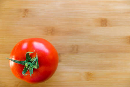 Mountain of red tomatoes on a wooden boardの写真素材