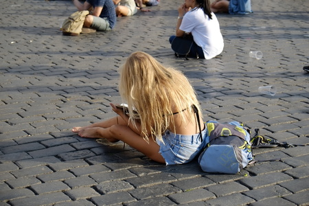 Prague, Czech Republic - July 17: The girl sit on the pavement on July 17, 2015 in Prague, Czech Republicのeditorial素材