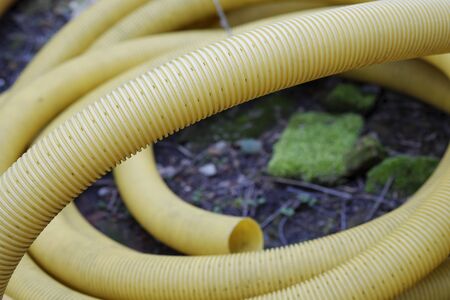 Yellow twisted pipe lying in the garden.の写真素材