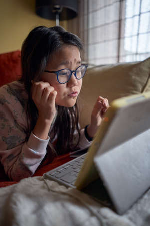 Girl studying at home with laptop in confinement for coronavirusの写真素材