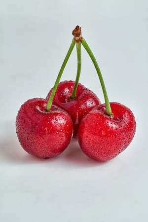 Bunch of three cherries, summer seasonal fruit, isolated on white backgroundの写真素材