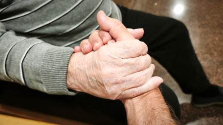A man and an elderly man hold hands. The scene is warm, comforting, and reflects love and understanding.の写真素材