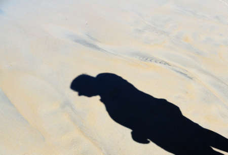 human shadow projected on the sandの写真素材
