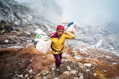 Miner at Kawah Ijen in Java, Indonesia carries sulfer out of the craterのeditorial素材