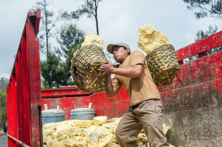 Worker at Kawah Ijen sulphur mine brings his sulphur to the truckのeditorial素材