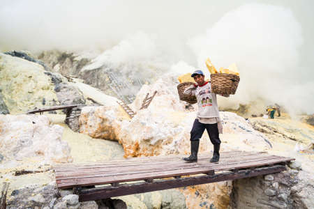 Worker at Kawah Ijen in Java, Indonesia carries sulfurのeditorial素材