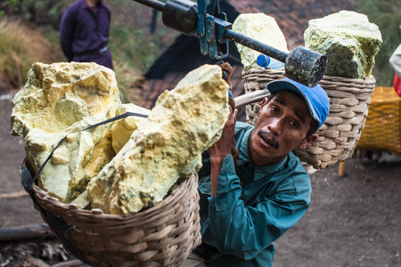 A worker at Kawah Ijen Java Indonesia weighs his basket of sulfur.
