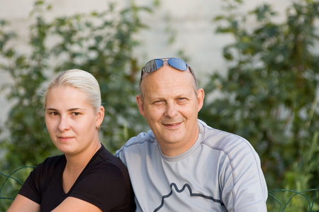 Senior man sitting next to yong wifeの写真素材