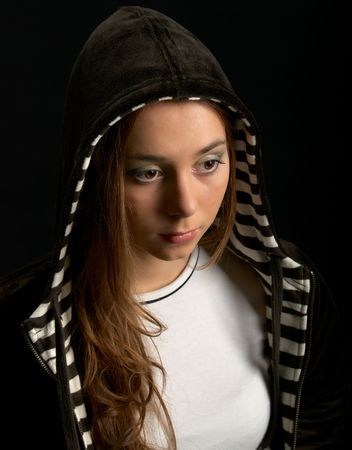 Young girl in hood against a dark backgroundの写真素材