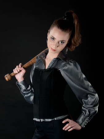 Young girl keeps baseball bat on hers shoulder and smirksの写真素材