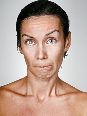 Facial portrait of offended woman with drops on a skinの写真素材