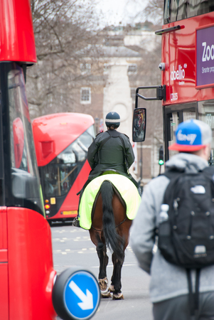 London, England. 06 march, 2016. Bobbies on horseback on the street between the traditional double-decker busのeditorial素材