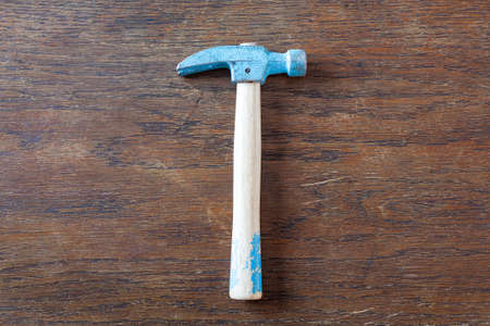 Old rustic toy carpenter hammer on wooden table.の写真素材