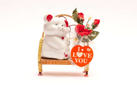 Isolated bear sitting on a bench with flowers and heart.の写真素材