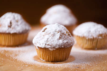Homemade cupcakes on a wooden cutting board.の写真素材